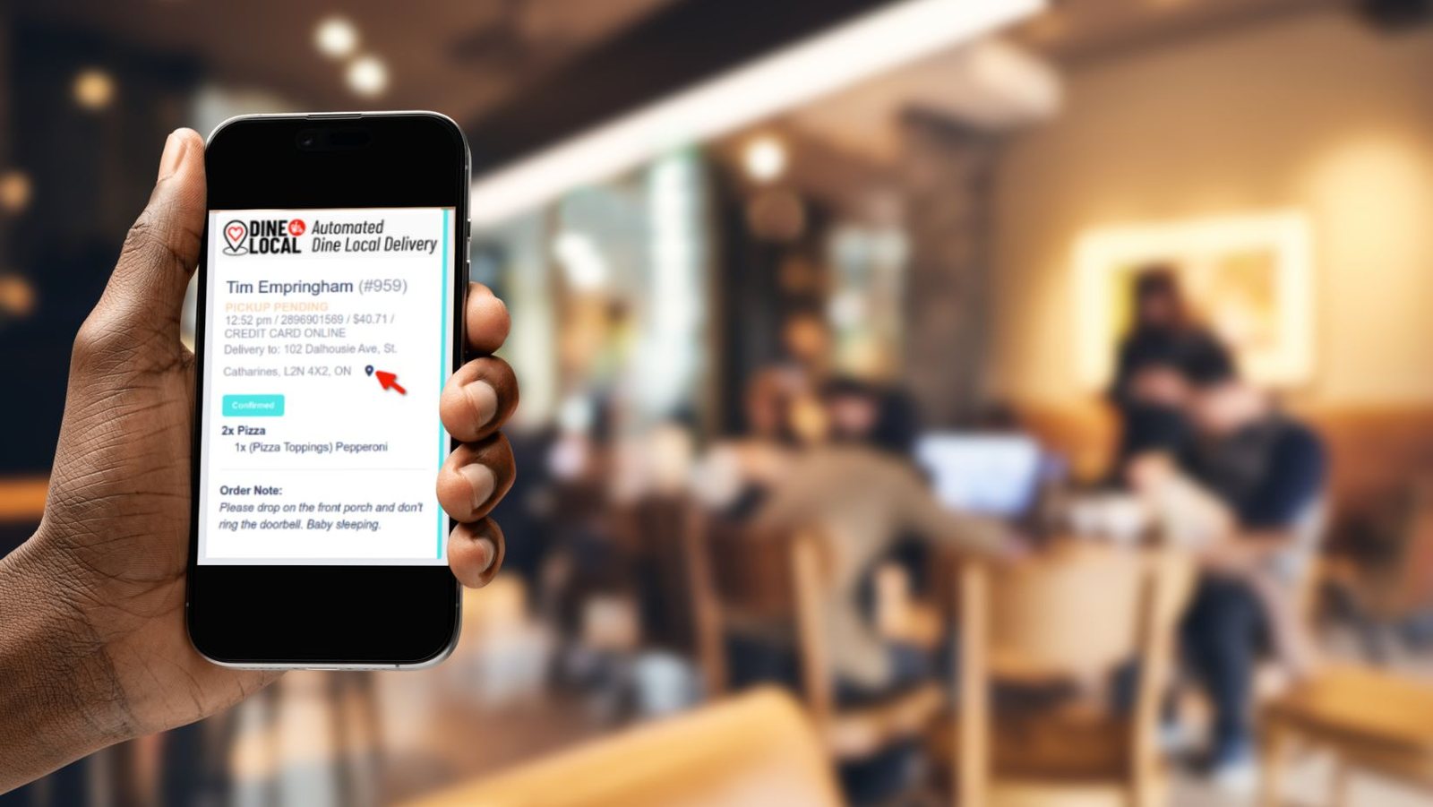 Photo of a cell phone with an order summary showing in front of a busy restaurant showing how simple it is to process takeout orders using the Dine Local direct ordering and delivery platform.