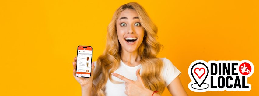 Picture of a woman holding a phone with the Dine Local App pointing at the phone with the look of surprise and delight indicating her pleasure with the delivery discount she is receiving.