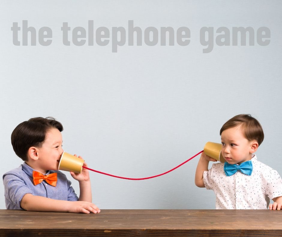 Photo of two children playing the telephone game.